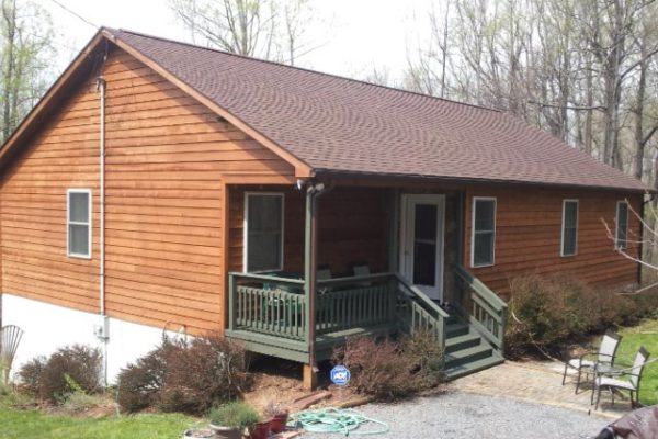 Home with wood siding and brown roof