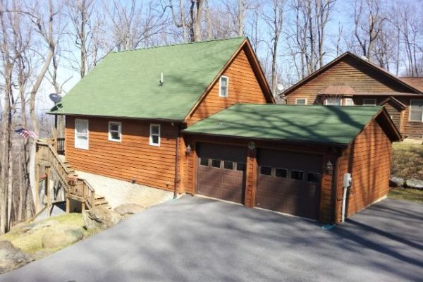 Home with wood siding and green shingled roof