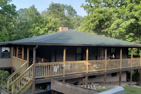 Home with wraparound porch with new green roof