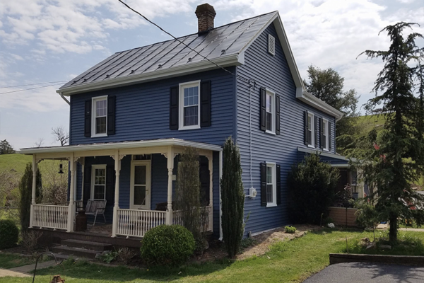 Blue historic home with dark metal roof