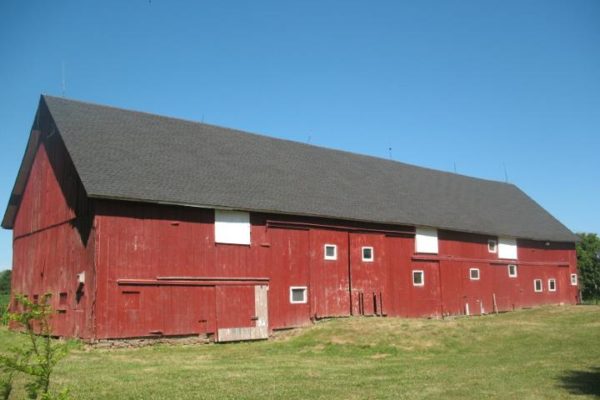 Red barn with large shingled roof